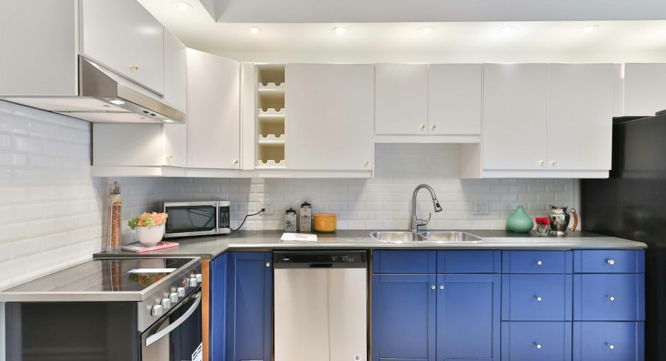 a-kitchen-with-blue-cabinets-and-a-black-refrigerator